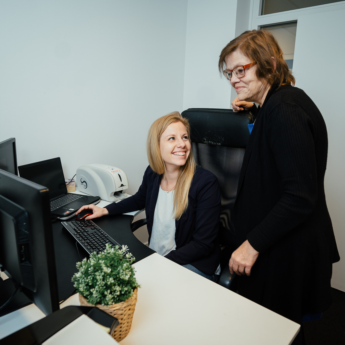 Two colleagues working through back-office administration at a desk in Denmark