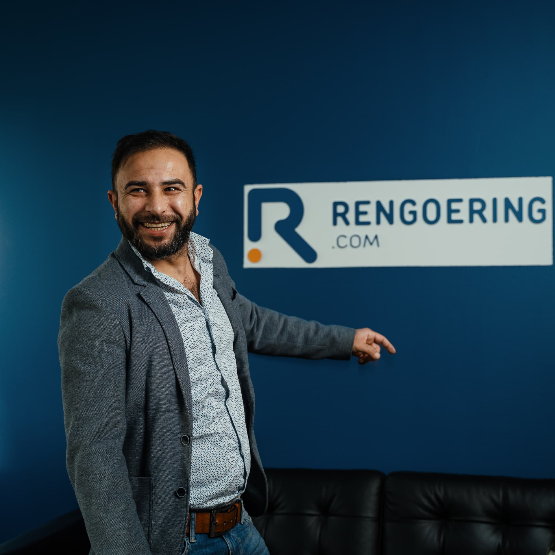 Qasem Ashraf at the Rengoering.com office in Denmark, next to the company logo